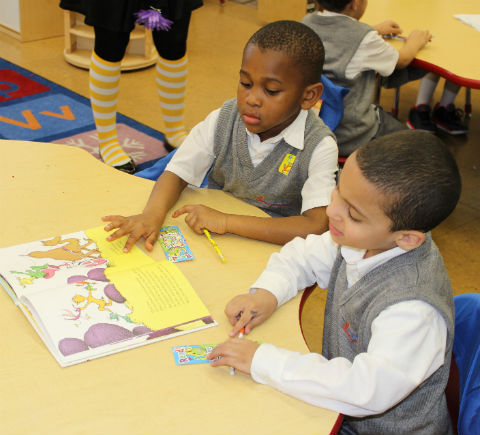 two students sitting at a desk and reading