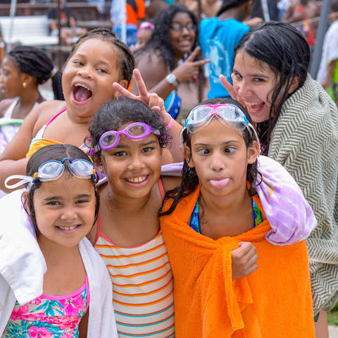 Kids at a swimming pool being silly.