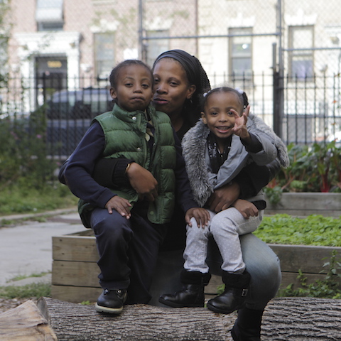 Kids sitting with a woman smiling.