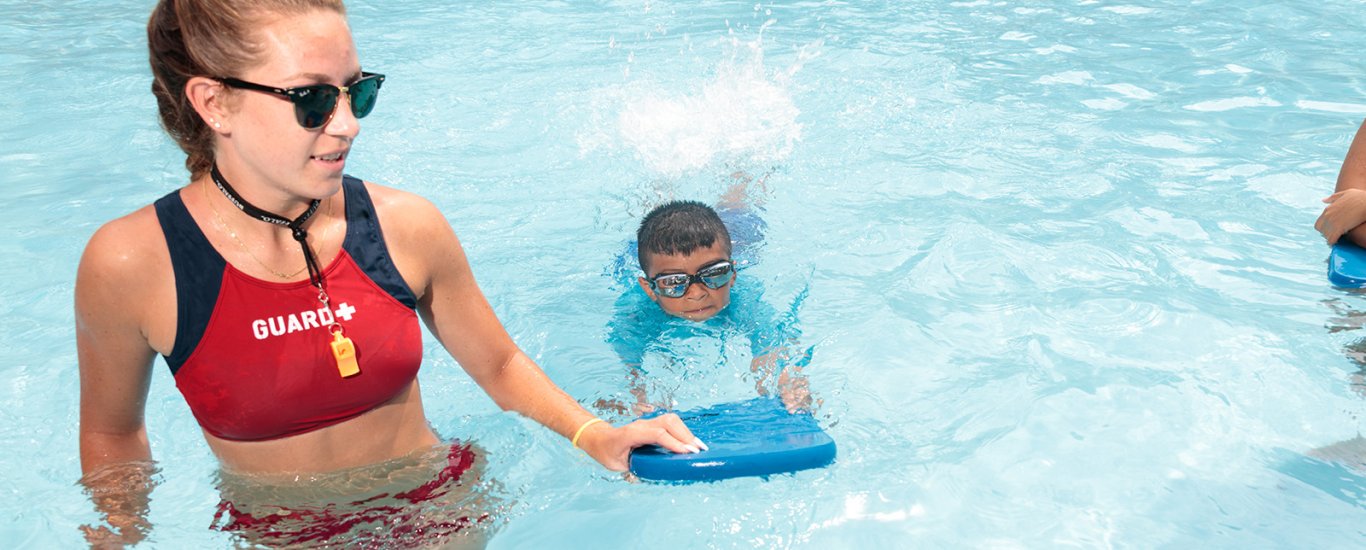 Lifeguard with student swimmer at the Children's Aid Goodhue Pool