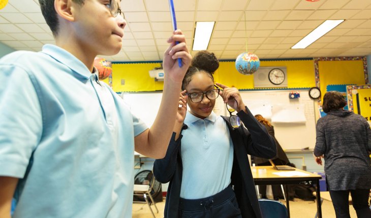 Students try on glasses provided by Helen Keller International