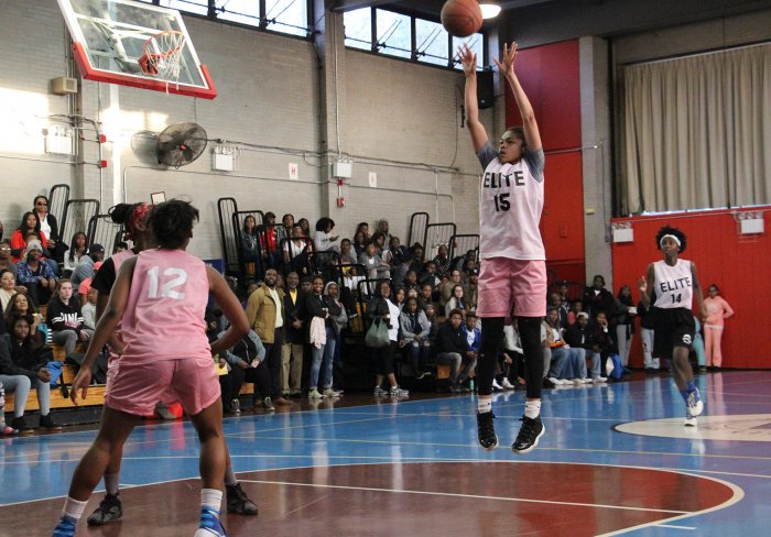 Young female basketball player attempts a jump shot.