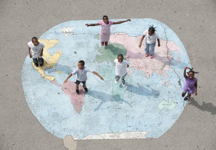 Children standing on a drawing of a world