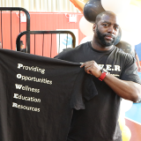 P.O.W.E.R. shirt displayed in indoor basketball court