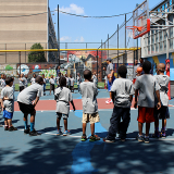 Children learning basketball on a playground