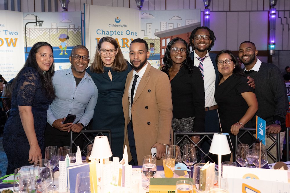 Phoebe Boyer posing with a second staff table at the benefit