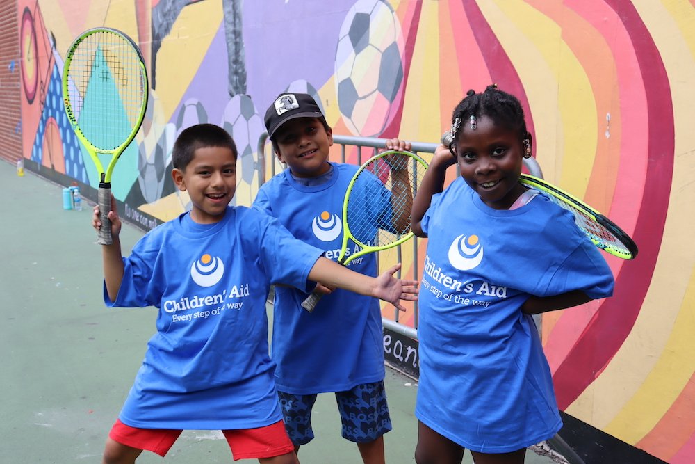 Students posing with tennis raquet