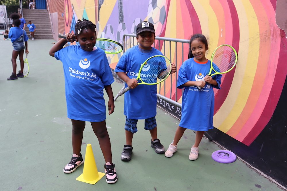 Students posing with tennis raquet