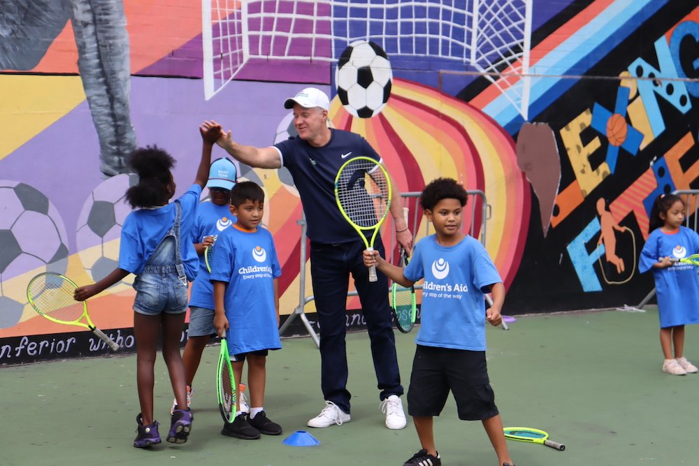 Student high-fiving with Patrick McEnroe